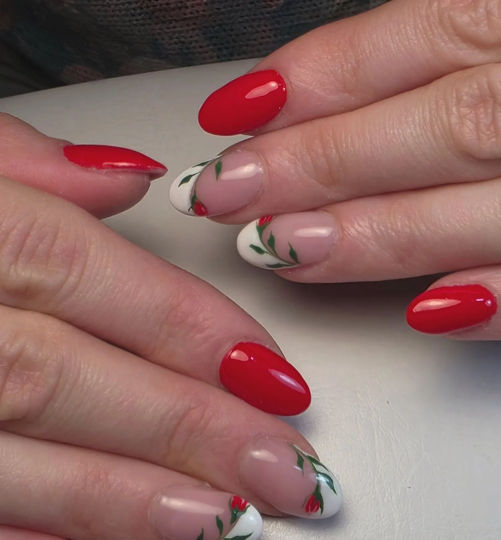 Rode amandelnagels en witte french tips met handgetekende rode roosjes