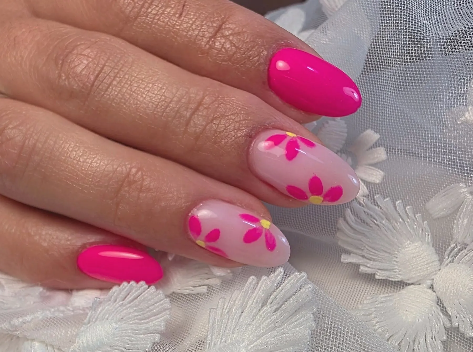 Fuchsia nagels, twee lichtroze nagels met getekende roze bloemen
