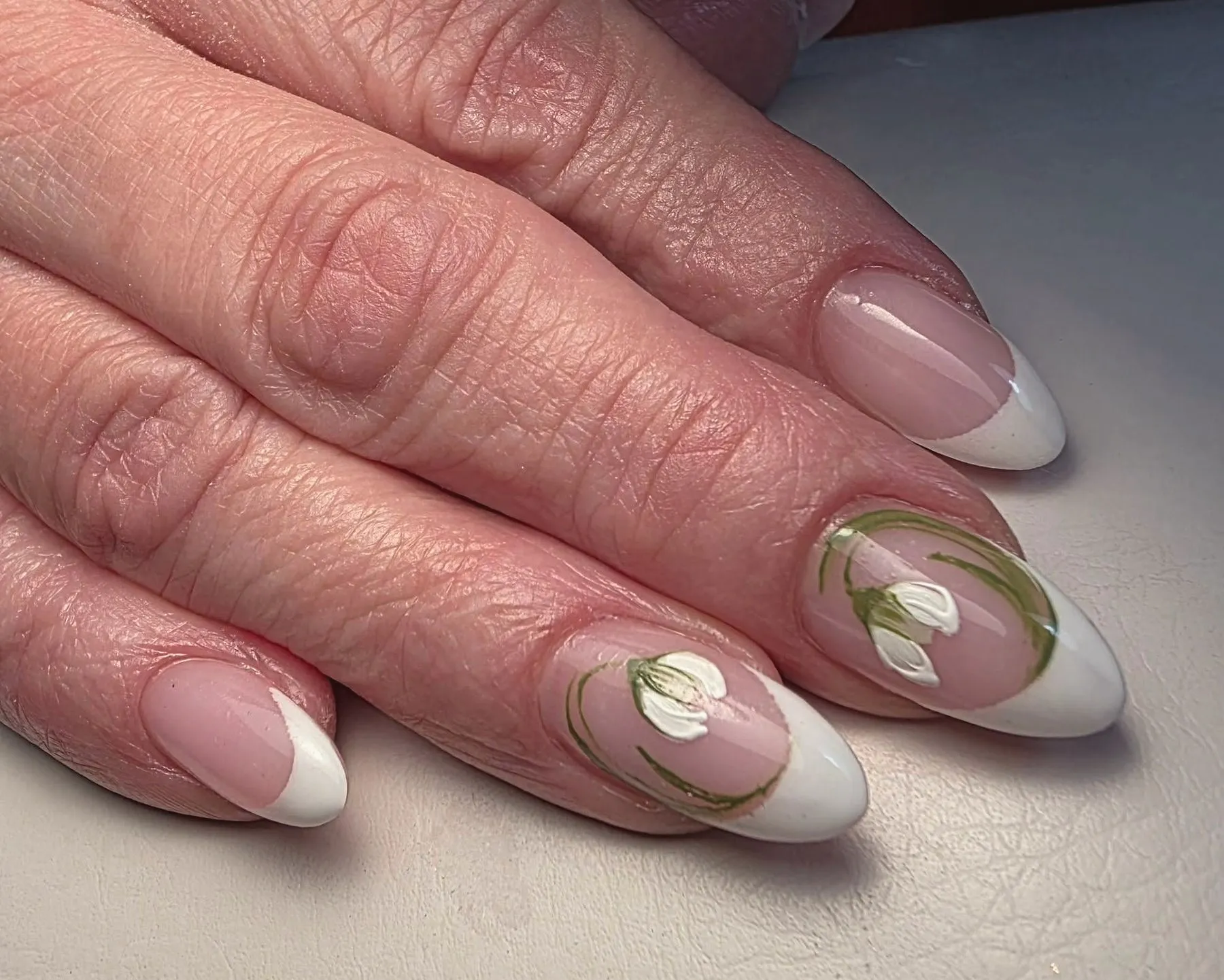 Witte french nagels met fijn getekende sneeuwklokjes